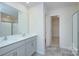 Bathroom with double sinks, gray cabinets, a mirror, a shower, and an entrance to the walk-in closet at 427 Carolina Hemlock Dr, Locust, NC 28097