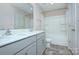 Modern bathroom featuring a double vanity with gray cabinets, a tub-shower combo, and neutral tile flooring at 427 Carolina Hemlock Dr, Locust, NC 28097