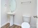 Bathroom with a modern pedestal sink, oval mirror, and a white toilet at 427 Carolina Hemlock Dr, Locust, NC 28097