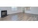 Open living area with fireplace, large window, and adjacent kitchen bar area at 427 Carolina Hemlock Dr, Locust, NC 28097