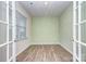 Neutral office space featuring French doors, light green wall, and wood-look flooring at 427 Carolina Hemlock Dr, Locust, NC 28097