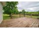 View of the home's wood back deck, overlooking the lawn and wooded area at 5129 Whitetail Ct, Crouse, NC 28033