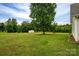 Large back yard with mature trees, fire pit, and shed in the background at 5129 Whitetail Ct, Crouse, NC 28033