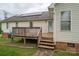 Backyard view of a white vinyl sided home featuring solar panels and wooden deck with railings at 5129 Whitetail Ct, Crouse, NC 28033