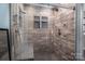 Stunning walk-in shower with wood-style tile, bench, and multiple shower heads at 5129 Whitetail Ct, Crouse, NC 28033