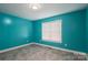 This colorful bedroom features blue walls, tile flooring, a window with blinds and a recessed light at 5129 Whitetail Ct, Crouse, NC 28033