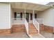 Inviting front porch with brick steps, white railings, and a covered entryway offering curb appeal at 5129 Whitetail Ct, Crouse, NC 28033