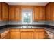 Functional kitchen featuring oak cabinets, granite countertops, and stainless steel sink at 5129 Whitetail Ct, Crouse, NC 28033