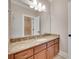 Bathroom with marble countertops, wood cabinets and a large, bright mirror at 5164 Mill Race Ln, Lancaster, SC 29720
