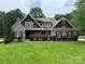 Charming stone and shingle home with lush landscaping and well-manicured lawn at 5164 Mill Race Ln, Lancaster, SC 29720