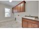 Bright laundry room with tile flooring, overhead cabinets and a utility sink at 5164 Mill Race Ln, Lancaster, SC 29720