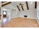 Living room with a fireplace, hardwood floors, and wooden beam vaulted ceiling at 5164 Mill Race Ln, Lancaster, SC 29720