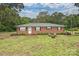 Charming brick home featuring a well-maintained yard and a cozy firepit area for outdoor enjoyment at 5222 Sikes Mill Rd, Monroe, NC 28110
