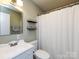Clean bathroom featuring a toilet, a shower behind a curtain, and a sink at 5809 Sharon Rd # G, Charlotte, NC 28210