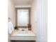 Charming bathroom with decorative mirror, neutral wallpaper, and elegant finishes at 5809 Sharon Rd # G, Charlotte, NC 28210