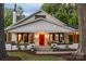 Charming home featuring a covered porch with inviting seating and a vibrant red front door at 606 1St W St, Conover, NC 28613