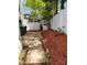 View of backyard featuring concrete patio, trash receptacles, and red mulch along white fence at 7107 Stonington Ln, Charlotte, NC 28227