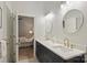 Bathroom with dual sinks, granite countertops, gold fixtures, and a glass enclosed shower at 718 W Trade St # 105, Charlotte, NC 28202
