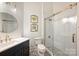 Well-lit bathroom features a glass shower, sleek vanity with gold hardware, and decorative wall art at 718 W Trade St # 105, Charlotte, NC 28202