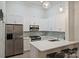 Bright kitchen features white cabinets, stainless steel appliances, and pendant lighting at 718 W Trade St # 105, Charlotte, NC 28202