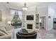 Cozy living room with fireplace, built-in shelves, balcony access and adjacent bedroom at 718 W Trade St # 105, Charlotte, NC 28202