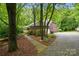 Charming brick home with mature trees, a driveway, and a welcoming walkway at 7725 Whitmire Ln, Mint Hill, NC 28227