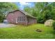 Brick home with a lush green lawn, featuring an outdoor fire pit and storage shed at 7725 Whitmire Ln, Mint Hill, NC 28227