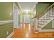 Inviting foyer with hardwood floors and staircase with white trim at 7725 Whitmire Ln, Mint Hill, NC 28227