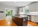 Kitchen features a center island with granite countertop and stainless steel appliances with an adjacent sunroom at 7725 Whitmire Ln, Mint Hill, NC 28227