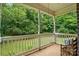 Covered porch with white railings, offers a view of the lush backyard at 7725 Whitmire Ln, Mint Hill, NC 28227