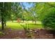 Expansive green yard surrounded by mature trees and natural landscaping at 7725 Whitmire Ln, Mint Hill, NC 28227