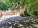 Brick home featuring backyard, two-car garage, basketball hoop, partial fence, and mature trees at 8218 Houston Ridge Rd, Charlotte, NC 28277