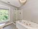Bright bathroom boasts a soaking tub, glass shower, and modern vanity with dual sinks at 8218 Houston Ridge Rd, Charlotte, NC 28277