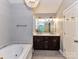 Bright bathroom boasts a soaking tub, glass shower, and modern vanity with dual sinks at 8218 Houston Ridge Rd, Charlotte, NC 28277