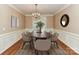 Elegant dining room with a chandelier, wainscoting, and a beautiful wood table set for six at 8218 Houston Ridge Rd, Charlotte, NC 28277