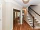 Elegant foyer with gleaming hardwood floors, staircase, and views of dining room at 8218 Houston Ridge Rd, Charlotte, NC 28277