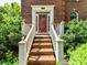 Inviting front door with brick steps and a white railing, leading to a classic brick home at 8218 Houston Ridge Rd, Charlotte, NC 28277