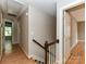 Hallway with hardwood floors featuring staircase with wood banister at 8218 Houston Ridge Rd, Charlotte, NC 28277