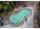 Unique kidney-shaped pool with stone surround, waterfall feature, and meticulously maintained landscaping at 8218 Houston Ridge Rd, Charlotte, NC 28277