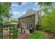 Charming backyard with brick patio, grill, mature trees, and outdoor seating at 8624 Canter Post Dr, Charlotte, NC 28216