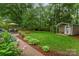 Expansive backyard featuring a patio, seating, shed and lush garden at 8624 Canter Post Dr, Charlotte, NC 28216