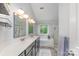 Bright bathroom featuring double sinks, large mirrors, bathtub, and glass shower at 8624 Canter Post Dr, Charlotte, NC 28216