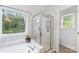 Modern bathroom showcasing a glass-enclosed shower and tub with window view at 8624 Canter Post Dr, Charlotte, NC 28216