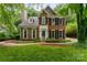 Charming brick and siding home with manicured lawn, mature trees and black shutters at 8624 Canter Post Dr, Charlotte, NC 28216