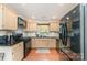 Well-lit kitchen featuring stainless steel appliances, granite countertops, a window above the sink, and wood flooring at 8624 Canter Post Dr, Charlotte, NC 28216