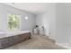 Bedroom features a gray quilt bed, a bright window, and a clean carpet at 945 Heritage Pkwy, Fort Mill, SC 29715
