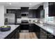Modern kitchen features stainless steel appliances, granite counters and stylish dark cabinetry at 10124 Florentine Way, Charlotte, NC 28214