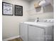 Convenient laundry area with a washer, dryer, shelving and decor, making laundry tasks efficient and organized at 10124 Florentine Way, Charlotte, NC 28214