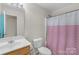 This bathroom features a sink, toilet, shower with curtain, and bright lighting at 1023 Valley Ridge Rd, Charlotte, NC 28214