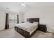 This bedroom features a large bed, vaulted ceilings, a ceiling fan, neutral walls, and a window with curtains at 1023 Valley Ridge Rd, Charlotte, NC 28214